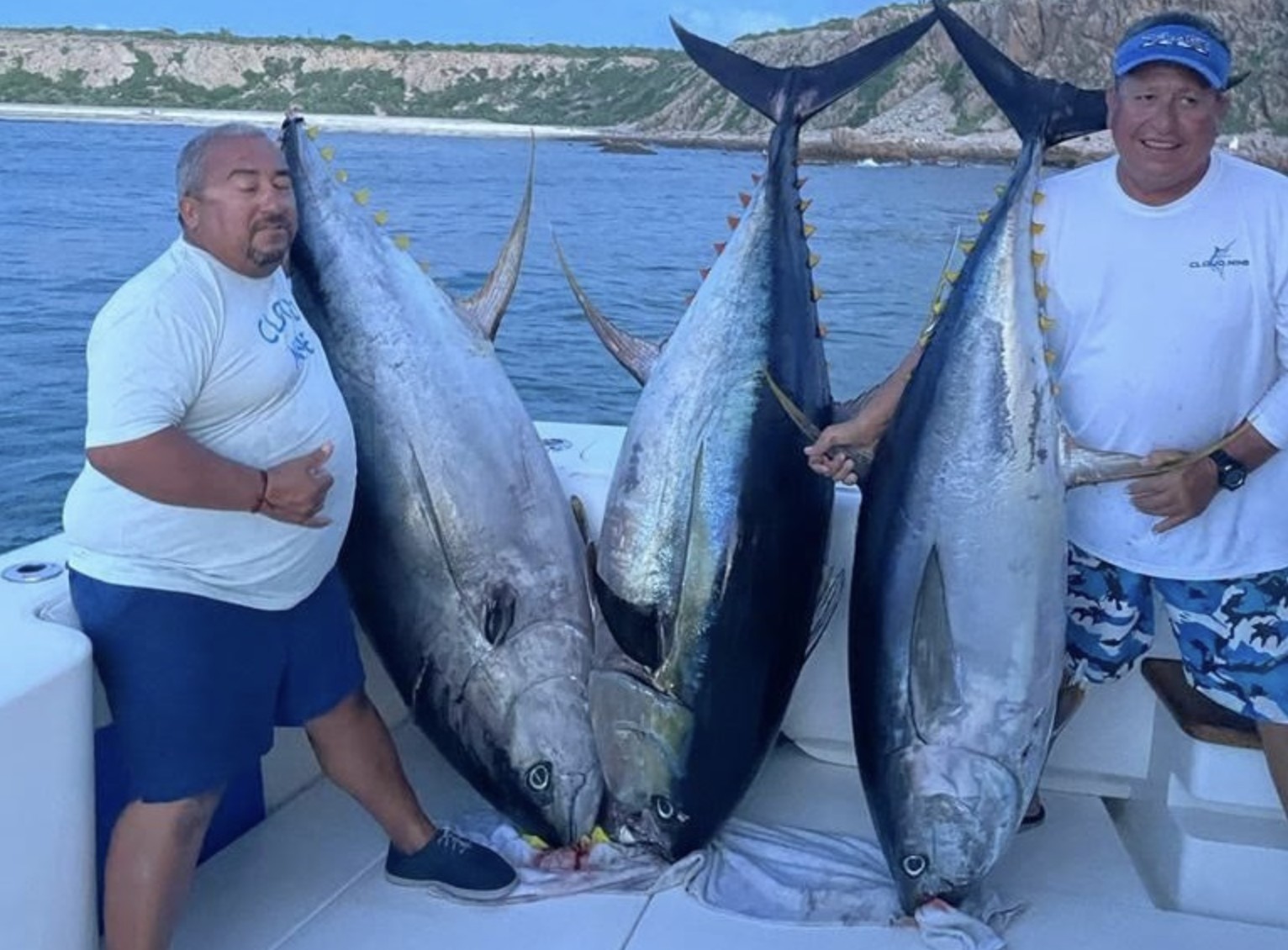 Two anglers with a trio of cow yellowfin tuna boatside in Cabo
